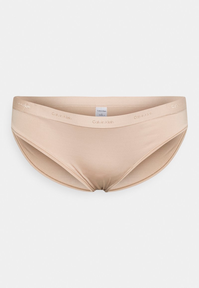 Boxer bege sem costura com uma textura suave e lisa. Apresenta um logótipo da Calvin Klein na cintura. Projetado para conforto e mínima visibilidade.