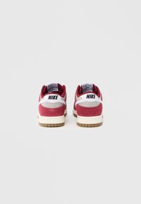 Crvene antilop tenisice s bijelim akcentima, imaju jastučićasti ovratnik i gumeni potplat s teksturiranim hvataljkama. Nike logo na peti.