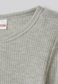 Pullover grigio a coste con scollo rotondo. Presenta un tessuto morbido e texture, con un delicato dettaglio di cucitura intorno al collo e alle spalle.