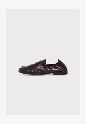 Dunkelbrauner Penny-Loafer aus Leder mit niedrigem Absatz, gerafften Seiten und klassischer Mokassinspitze, im Profil auf weißem Hintergrund dargestellt.