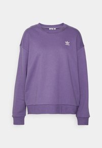 Fialová mikina z měkkého materiálu, má kulatý výstřih, žebrované manžety a malé bílé logo Adidas na hrudi.