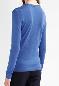Pull bleu en tricot à manches longues, avec un col rond et des bords côtes aux poignets et à l'ourlet. Texture lisse avec un motif uni.