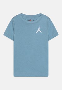 Jasnoniebieska koszulka z krótkim rękawem wykonana z bawełny, z białym haftowanym logo Jumpman na klatce piersiowej. Okrągły dekolt i prosty design.