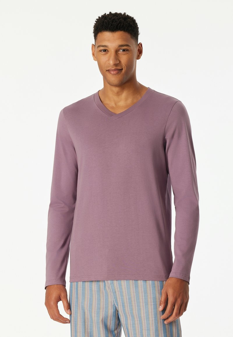 Long-sleeve V-neck shirt in light purple fabric, featuring a smooth texture. Paired with striped blue and white pajama bottoms.