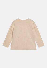 Pitkähihaisessa beige T-paidassa on pehmeä rakenne, pyöreä kaula-aukko ja rypytettyjä yksityiskohtia hihoissa. Yksinkertainen, koristelematon muotoilu.