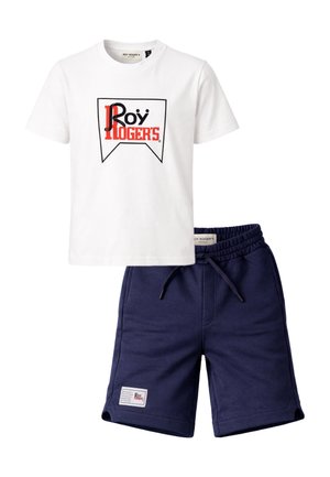 T-shirt bianca a maniche corte con logo "Roy Roger's" rosso e nero abbinata a pantaloncini blu navy con vita elasticizzata e toppa frontale.
