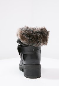 Černá kožená bota s faux kožešinovým lemem, detailem kovové spony, blokovým podpatkem a texturední podrážkou, navržená pro pohodlí a trvanlivost.