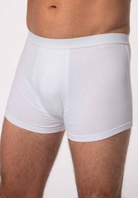 Boxer da uomo bianchi in cotone con una morbida fascia elasticizzata, caratterizzati da un logo testurizzato, un design aderente e una superficie di tessuto liscia.