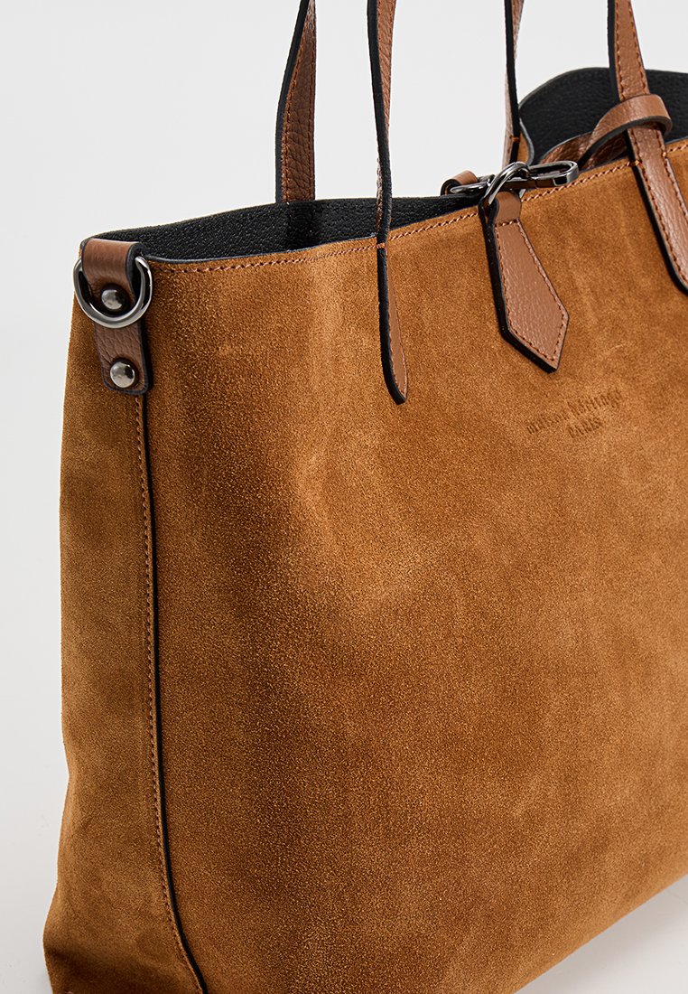 Braune Wildleder-Tote-Tasche mit Lederakzenten, doppelten Griffen und silbernem Beschlag. Glatte Textur mit subtilen Steppnähten.