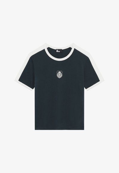 Camiseta de algodón azul marino con mangas de acento blanca. Presenta un pequeño emblema bordado en el pecho y un clásico cuello redondo.