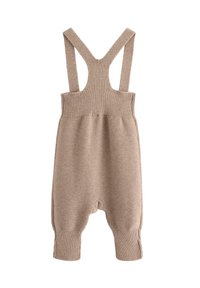 Beige strikket heldragt med brede stropper, ribbet tekstur og opkrøllede kanter. Designet til komfort og nem at have på.
