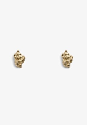 Boucles d'oreilles clous dorées avec une forme organique irrégulière, surface texturée et petits détails. Design minimaliste qui capte la lumière.
