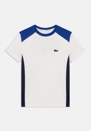 Wit T-shirt met korte mouwen, met blauwe schouderpanelen en zijstrepen, voorzien van een klein groen krokodillenlogo op de linkerborst.