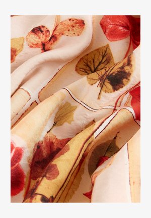 Tissu avec un motif floral présentant des feuilles orange-rouge, jaunes et vertes sur un fond beige clair, texture lisse et drapé fluide.