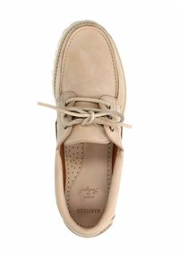 Beige Wildlederschuh im Bootsstil mit runder Zehenpartie, Schnürverschluss und perforierter Innensohle. Mit kontrastierenden braunen Akzenten und einer strukturierten Gummisohle.
