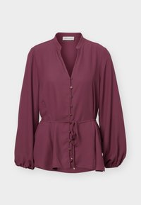 Μπλούζα με μακριά μανίκια σε αποχρώσεις δαμάσκηνου, με μανδύα μανταρίνι, μπροστινά χρυσά κουμπιά και ζώνη στη μέση, με ελαφρώς φουσκωτή ρίγα και μανσέτες με πιέτες.