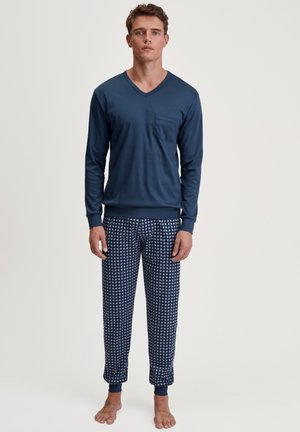 Marineblauwe blouse met lange mouwen en een V-hals, voorzien van een zak, gecombineerd met gemusterde pyjamabroek in marineblauw en wit, met elastische manchetten.