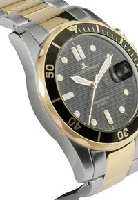 Reloj de acero inoxidable con un dial negro texturizado, acentos dorados y un bisel estilo buceador. Presenta marcadores luminosos y una pantalla de fecha.