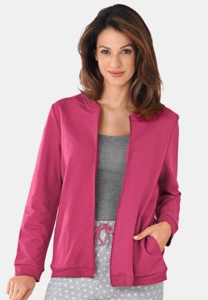 Fuchsia Zip-Jacke mit Rundhalsausschnitt und zwei Taschen. Graues Tanktop darunter. Weicher, glatter Stoff mit gerippten Manschetten.