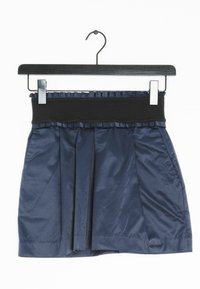 Námornická plisovaná sukně s černým elastickým pasem, vyrobená z hladkého materiálu. Má volánkový lem podél pasu a rovný lem.
