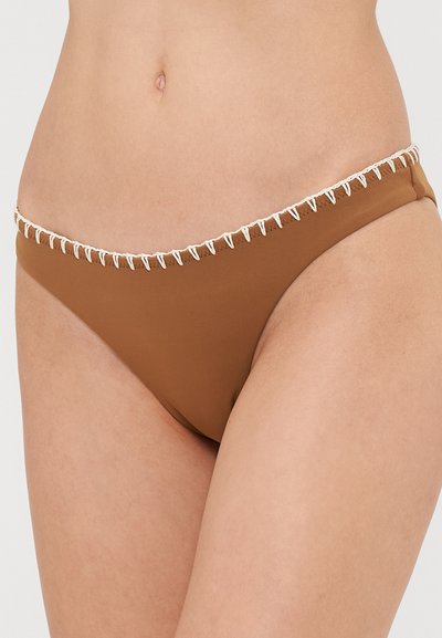 Rudas bikini kelnaitės su tekstūruota juosmeniu, išsiskiriančiu kontrastinga balta siūle. Lygus audinys, žemas juosmuo ir minimalistinis stilius.