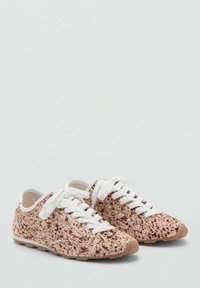 Zapatillas con una parte superior de textil moteado de color marrón claro, cordones blancos y suelas de goma. Diseño de perfil bajo con puntera redondeada y un interior acolchado.