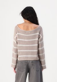 Gestreifter, leichter Pullover in Beige und Weiß mit lockerer Passform und weitem Ausschnitt. Verfügt über eine gestrickte Textur und cropped Länge.