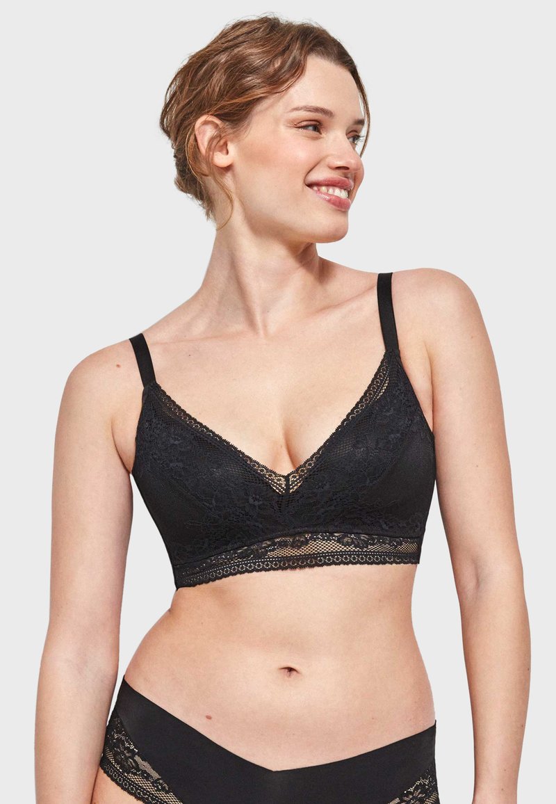 Černý krajkový bralet s V-výstřihem, nastavitelnými ramínky a širokým krajkovým páskem. Vyrobený s jemnými květinovými vzory a hladkou texturou.