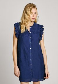 Marineblaues, ärmelloses Kleid mit Rüschendetails an den Schultern, Knopfleiste und strukturiertem Stoff. Gerade geschnitten mit lockerer Passform.