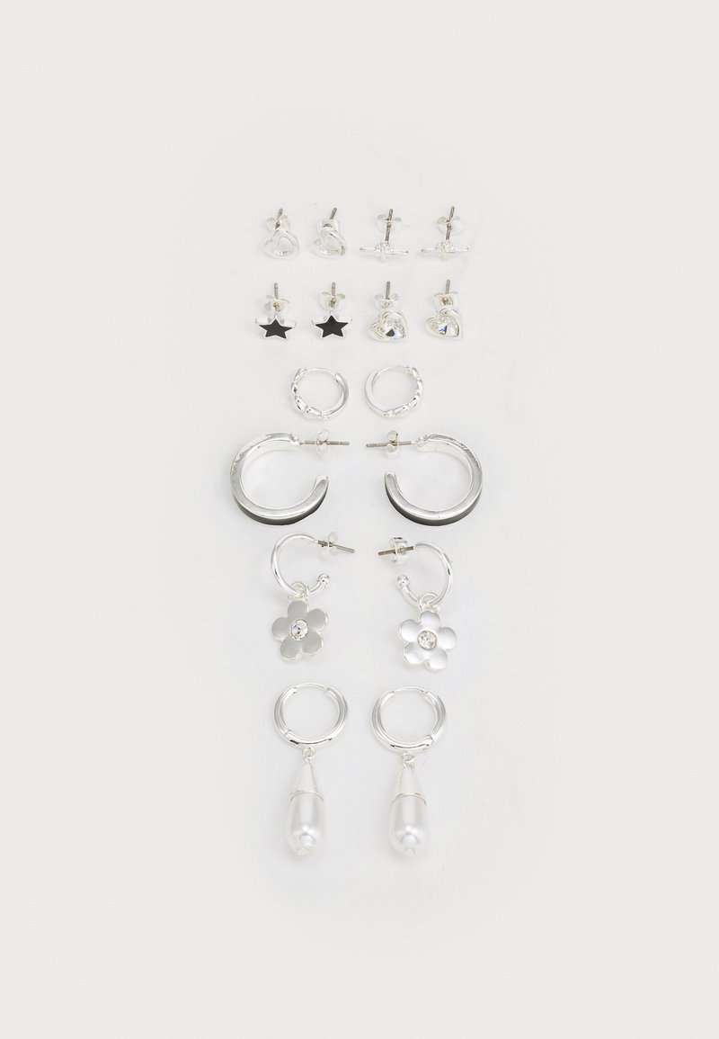 Sada strieborných náušníc vrátane puzetových a kruhových, s kvetinovými vzormi, hviezdami, perlami a rôznymi textúrami a povrchovými úpravami.