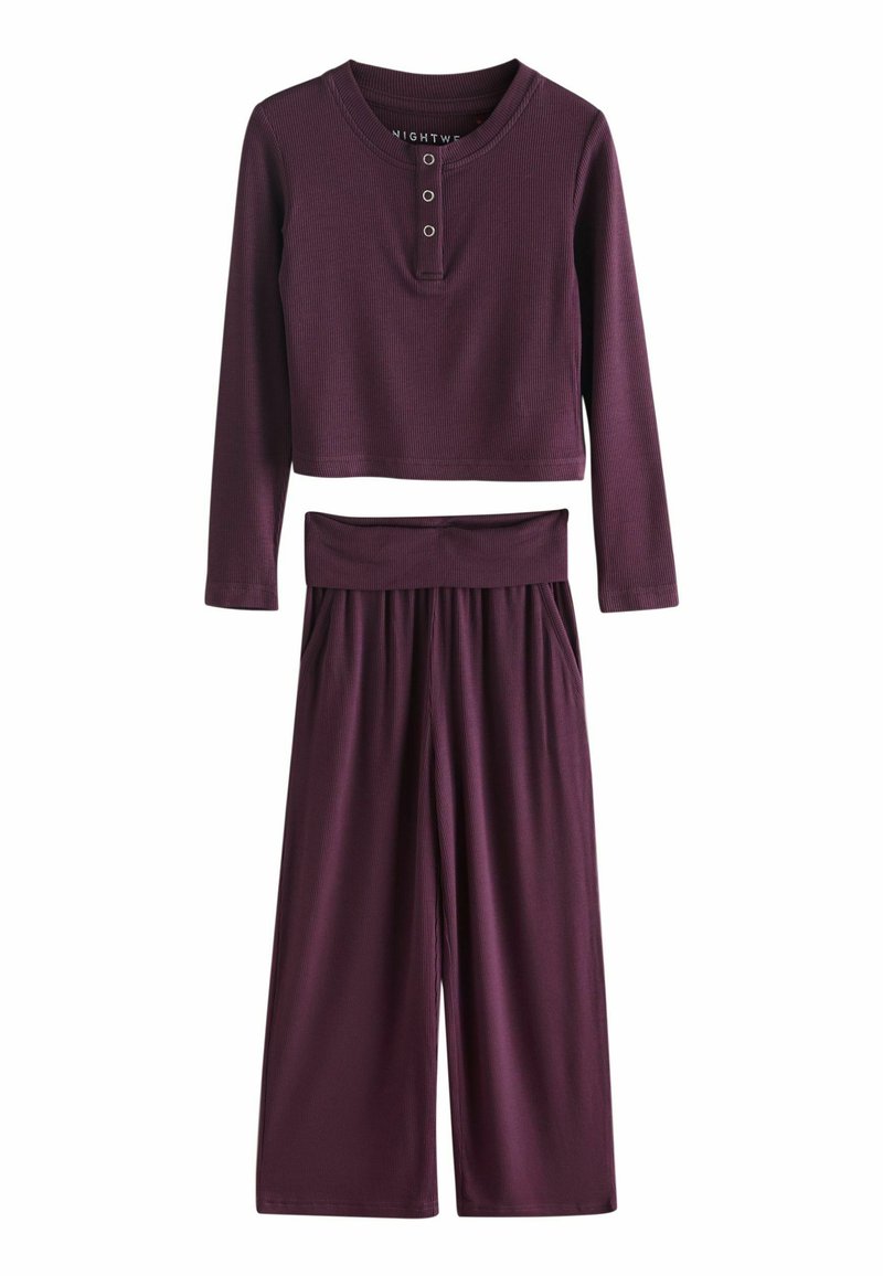 Compleu de loungewear cu prindere purpurie, format dintr-un top scurt cu mâneci lungi și detalii cu butoane, împreună cu pantaloni cu croi larg și talie elastică.