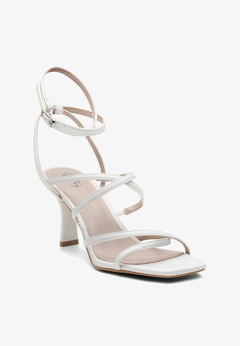 Baltos kulniukais sandalai su keliomis plonomis juostelėmis, kvadratiniu priekiu ir vidutinio aukščio blokuotu kulnu. Lygi oda su subtiliu blizgesiu.