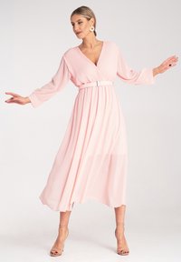 Różowa, midi sukienka z głębokim dekoltem w serek i długimi rękawami, z plisowanymi detalami i dopasowanym paskiem. Materiał jest miękki i zwiewny.