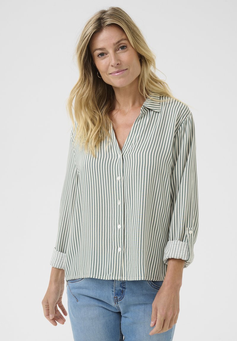 Camicia a righe verde chiaro e bianca, con chiusura frontale a bottoni, colletto e maniche arrotolate; realizzata in un tessuto leggero.