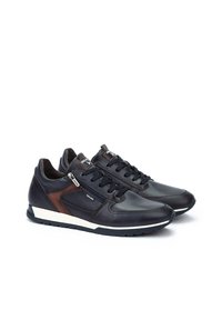 Sneaker in pelle nera con un accento marrone, caratterizzati da un design elegante, superiore testurizzato, suola bianca e chiusura con lacci e cerniera laterale.