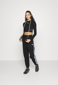 adidas Sportswear ESSENTIALS 3-STRIPES LOOSE-FIT - Spodnji deli trenirk - black/white