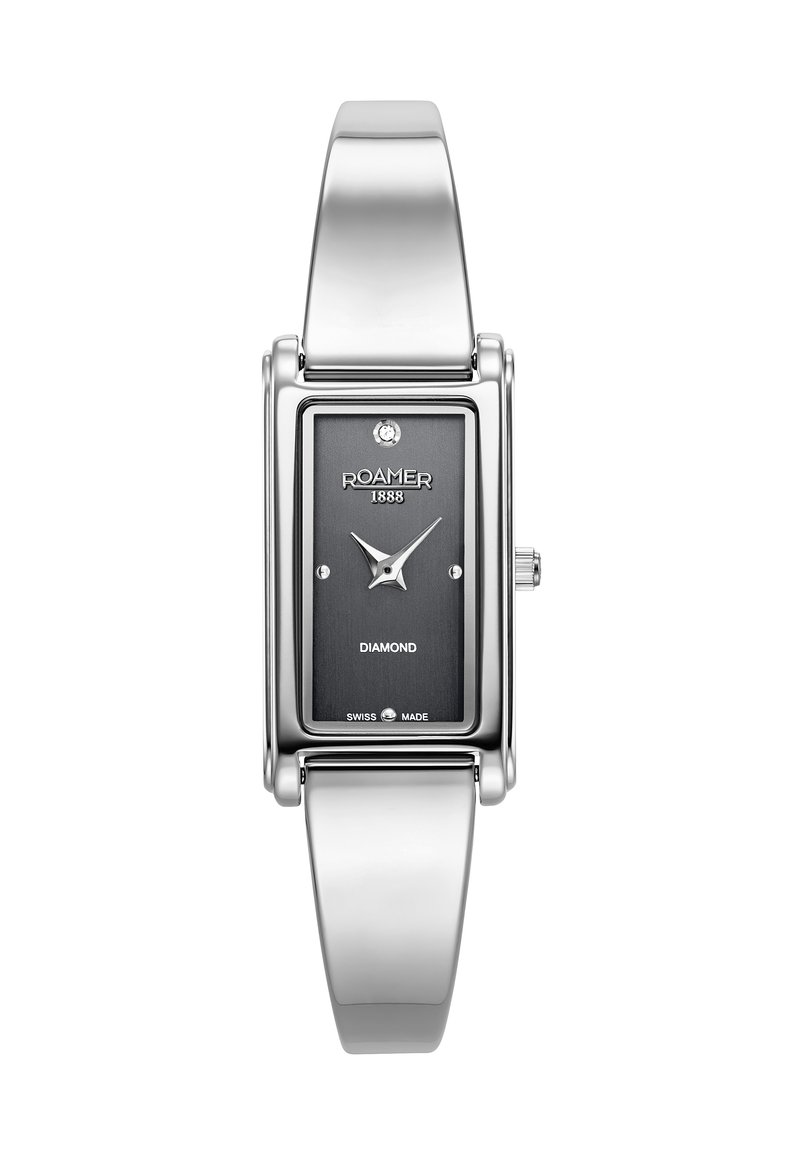 Reloj de pulsera plateado rectangular con cara negra, acento de diamante y banda de acero inoxidable. Presenta marcadores de hora minimalistas y logotipo.
