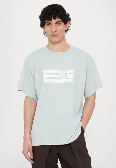 Ανοιχτό μπλε βαμβακερό μπλουζάκι με κοντά μανίκια, στρογγυλή λαιμόκοψη και λευκή γραφική παράσταση με οριζόντιες ρίγες και τον αριθμό 6 στο μπροστινό μέρος.