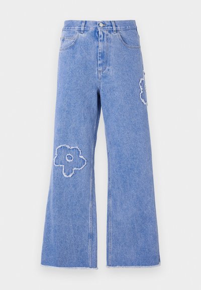 Light blue denim flared jeans featuring frayed hems and notable flower-shaped patches on both knees. Classic five-pocket design.