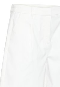 Pantalon blanc ajusté avec poches latérales, passants de ceinture et plis à l'avant, présenté de la taille jusqu'au milieu de la cuisse.