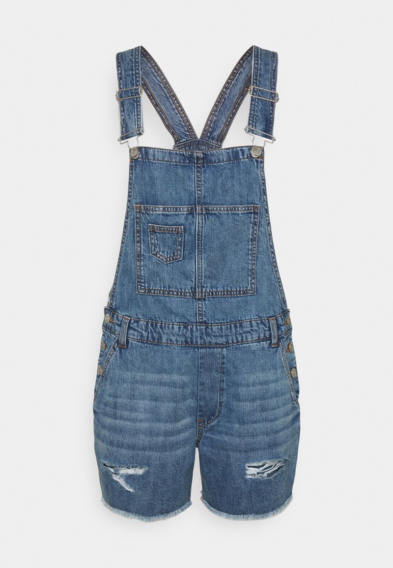 Salopette courte en denim bleu avec bretelles réglables, poche poitrine avant, boutons latéraux et déchirures effilochées sur les jambes.