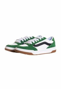 Grüne und weiße Sneakers aus Wildledermaterial, mit einem schwarzen Akzentstreifen, flachen weißen Schnürsenkeln und einer Gummisohle.