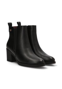 Botas de tobillo de cuero negro con un acabado texturizado, tacón cuadrado, paneles laterales elásticos y un pequeño acento metálico en el tacón.