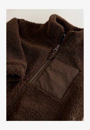 Braune Fleecejacke mit hohem Kragen, strukturiertem Äußeren, Reißverschluss und einer Stofftasche, mit dunklen braunen Akzenten.