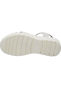 Witte sandaalzool met gestructureerde grooves, gemaakt van rubber, met een plat ontwerp en een lichte kromming, en minimale branding nabij de hiel.