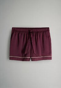 Pantalones cortos de pijama de raso burdeos con cintura elástica, lazada frontal y detalle de ribete beige claro a lo largo del dobladillo.