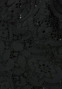Schwarzer Spitzenstoff mit floralen Mustern und offenem Gewebe, einer strukturierten Oberfläche und detaillierten, aufwendigen Designs.