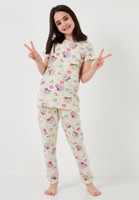 Pajama set kratkih rukava s svijetložutom pozadinom, koji sadrži šarene uzorke životinja i cvijeća na gornjem dijelu i hlačama.
