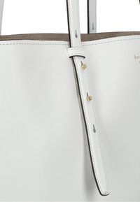Witte leren tote bag met een gladde textuur, voorzien van een enkele schouderband en gouden hardware-accenten.