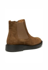 Bottines en suède marron avec panneaux latéraux élastiques et bout rond, dotées d'une semelle en caoutchouc noir contrastante pour une traction et un confort améliorés.
